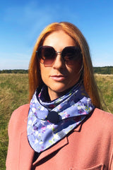 Frau trägt Halstuch für Damen aus hellblauer Baumwolle mit Blütenranken in Pastell Bunt, das Tuch wird mit einem Knopf verschlossen, damit es nicht verrutscht, gefüttert mit weichem, samtigen Baumwollnicki, Fair Wear, made with Love, sustainable, nachhaltig, liebe Deinen Planeten, praktisch, chic, alltagstauglich, Lieblingstuch