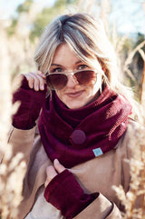 Junge Frau trägt Pulswärmer aus bordeauxrotem Cord