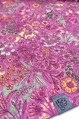 Stoffdetail von Dreieckstuch mit Knopf Fuchsia als Grundfarbe, Akzente in rosa, bordeaux, gelb, orange und salbei grün, Label von wishproject aus recycelten Materialien, traumhaft schönes Halstuch
