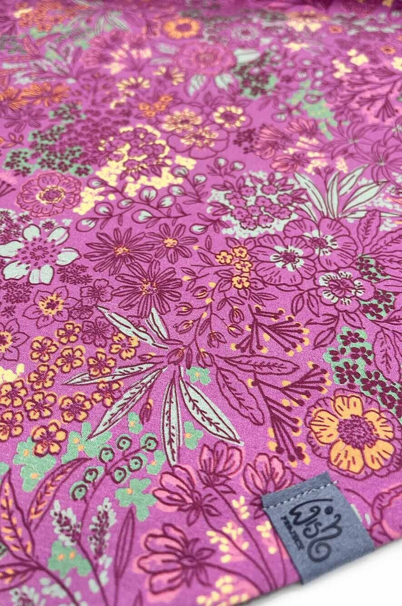 Stoffdetail von Dreieckstuch mit Knopf Fuchsia als Grundfarbe, Akzente in rosa, bordeaux, gelb, orange und salbei grün, Label von wishproject aus recycelten Materialien, traumhaft schönes Halstuch
