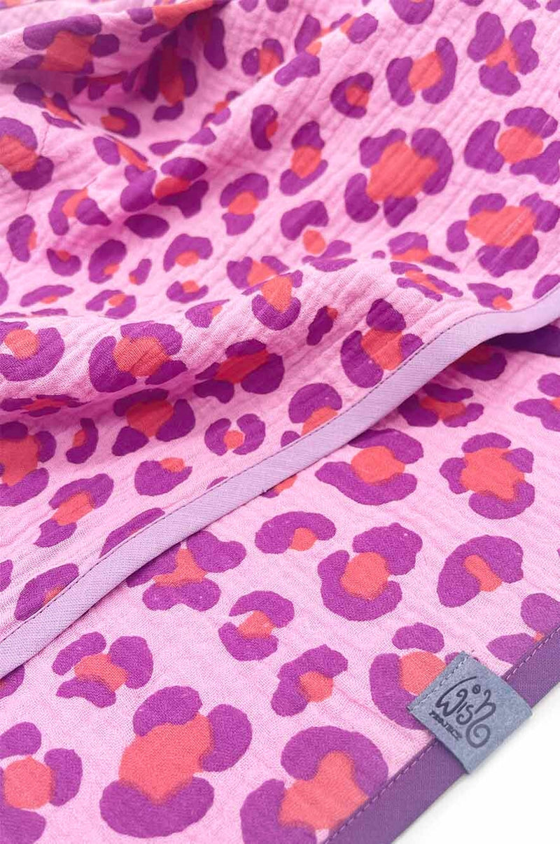 Detailansicht des rosa Halstuchs mit lila und orangefarbenem Leo-Muster aus weichem Musselin-Stoff – hochwertig verarbeitet mit lilafarbener Kante