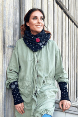 Junge frau mit dreieckstuch mit knopf schwarz mit pusteblumen und stulpen 