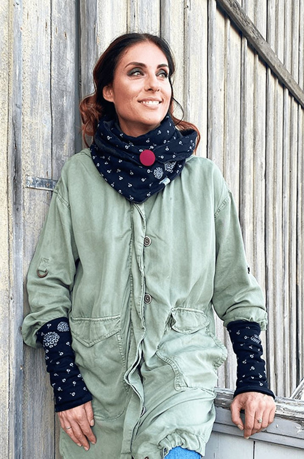 Junge frau mit dreieckstuch mit knopf schwarz mit pusteblumen und stulpen 
